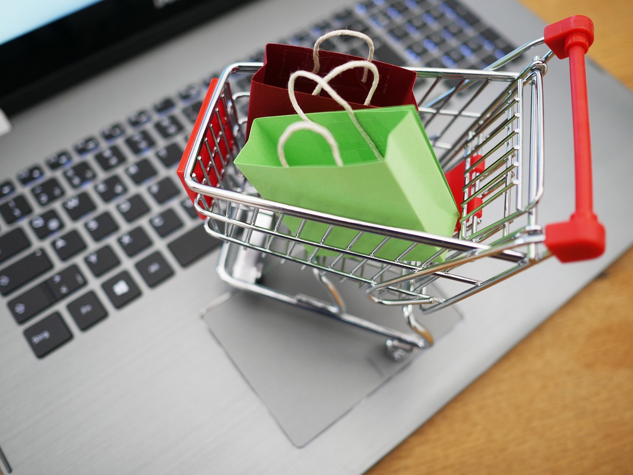 Notebook com carrinho de compras representando as faixas de preço para criar uma loja virtual