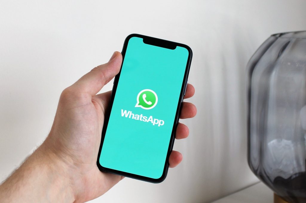 Smartphone com WhatsApp aberto representando um site com chatbot WhatsApp para atendimento de clientes